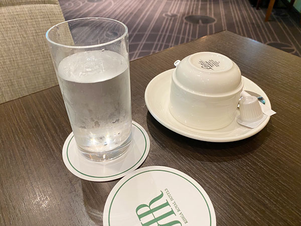 リーガロイヤルホテル大阪リモネのテーブルに置かれた水とコーヒーカップ